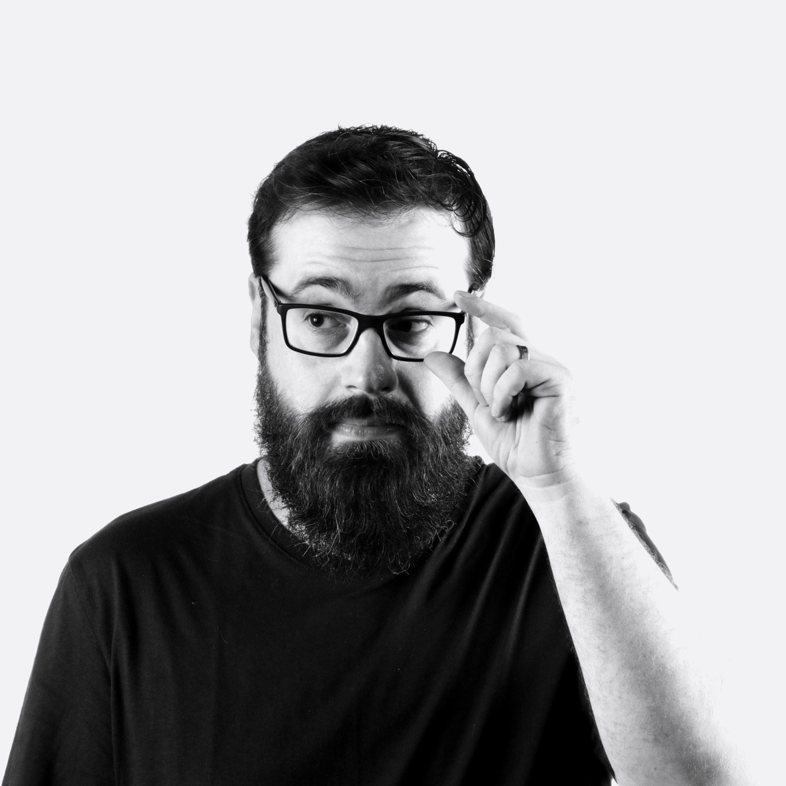 Michel Scoz, fundador da SCOZ, de óculos e barba, ajustando os óculos com a mão.